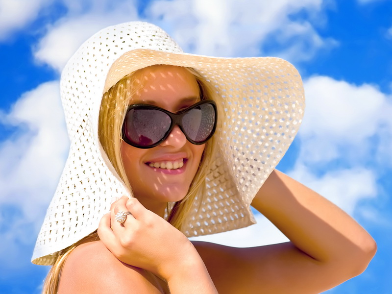 Young girl under hat in summer