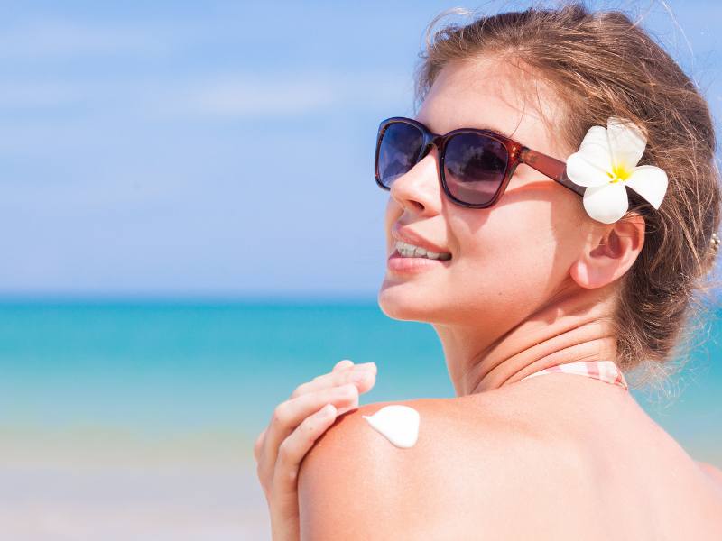 young-woman-in-sunglasses-putting-sun-cream-on-shoulder_1.bin