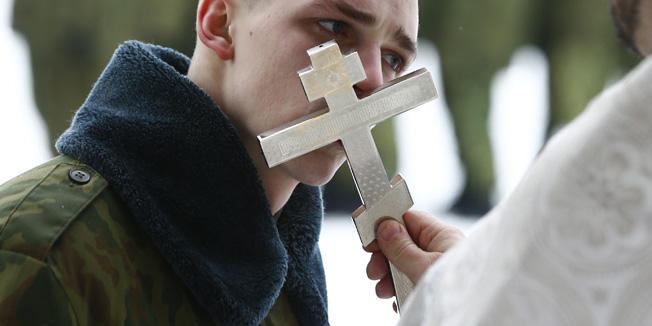 A serviceman of the Belarussian Interior Ministry's special force kisses a cross during a service to celebrate Orthodox Christmas at a military base in Minsk, Belarus January 7, 2016. Orthodox Christians celebrate Christmas on January 7, according to the Julian calendar. REUTERS/Vasily Fedosenko - RTX21EHD