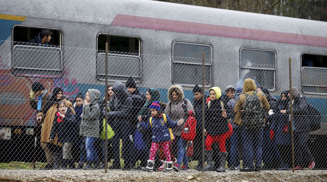 Migrants walk along a train upon their arrival at a makeshift train station close to the Austrian border town of Spielfeld in the village of Sentilj, Slovenia, February 16, 2016.    REUTERS/Leonhard Foeger      TPX IMAGES OF THE DAY     