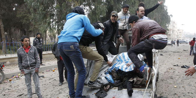 ATTENTION EDITORS - VISUAL COVERAGE OF SCENES OF INJURY OR DEATHPeople react next to dead bodies as they stand at the back of a truck near a site hit by what activists say was an air raid from forces loyal to Syria's President Bashar al-Assad in Raqqa, eastern Syria December 7, 2013. REUTERS/Nour Fourat (SYRIA - Tags: POLITICS CIVIL UNREST CONFLICT) TEMPLATE OUT - RTX16803