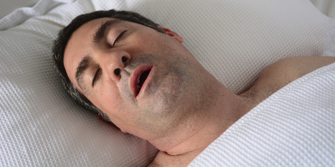 Man in his forties (40s) snoring in bed. Health care concept