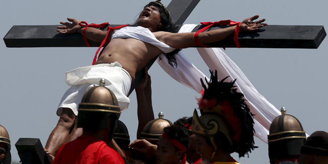 Penitent Ruben Enaje, in his 29th year of crucifixion, is raised on a wooden cross during a reenactment of the crucifixion of Jesus Christ on Good Friday in Cutud, San Fernando Pampanga north of Manila April 3, 2015.  REUTERS/Erik De Castro - RTR4VZI3