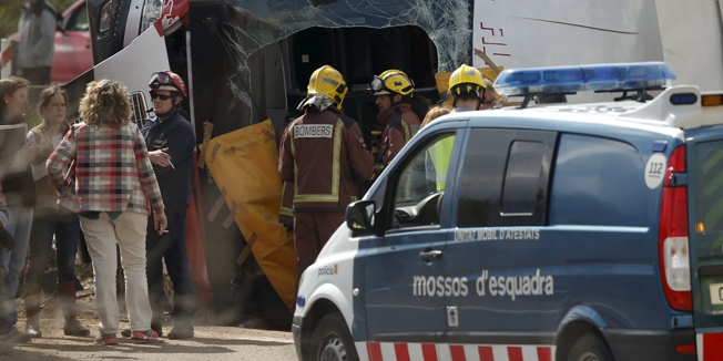 Firemen stands next to the wreckage of a bus after a traffic accident in Freginals, Spain, March 20, 2016.  REUTERS/Albert Gea