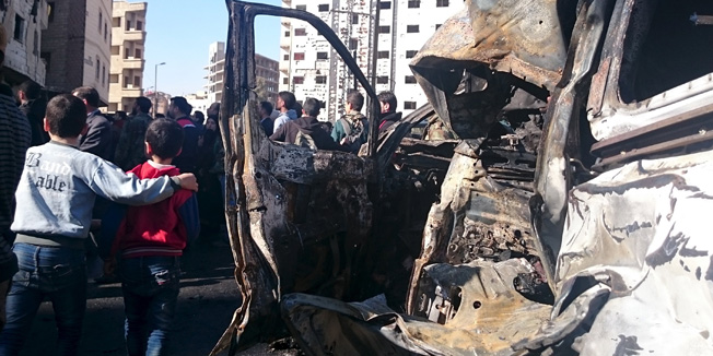 Children stand near damaged vehicles as residents and soldiers loyal to Syria's President Bashar al-Assad inspect damage after a suicide attack in Sayeda Zeinab, a district of southern Damascus, Syria January 31, 2016. At least 60 people were killed, including 25 Shi'ite fighters, and dozens wounded on Sunday by a car bomb and two suicide bombers in a district of Damascus where Syria's holiest Shi'ite shrine is located, a monitor said. Sunni fundamentalist Islamic State claimed responsibility for the attacks, according to Amaq, a news agency that supports the group. It said two operations 