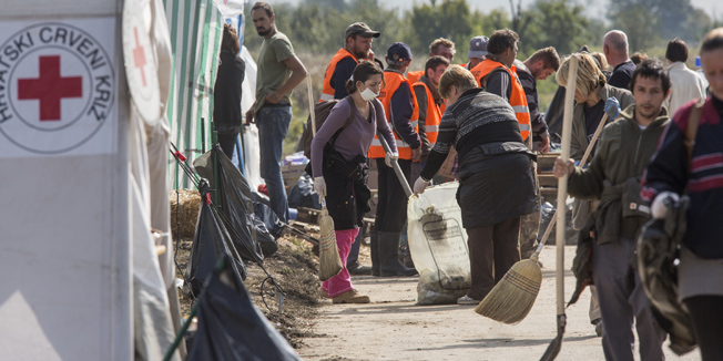 Bapska, 011015.Malogranicni prijelaz pored sela Bapska gdje izbjeglice iz Srbije prelaze u Hrvatsku.Na fotografiji:Volonteri u pauzi dok nema veci broj izbjeglica ciste cestu od smeca i blata.Foto: Bozidar Vukicevic / CROPIX 