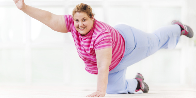 Young smiling fat woman doing stretching exercises and looking at the camera.[url=http://www.istockphoto.com/search/lightbox/9786766][img]http://dl.dropbox.com/u/40117171/sport.jpg[/img][/url]