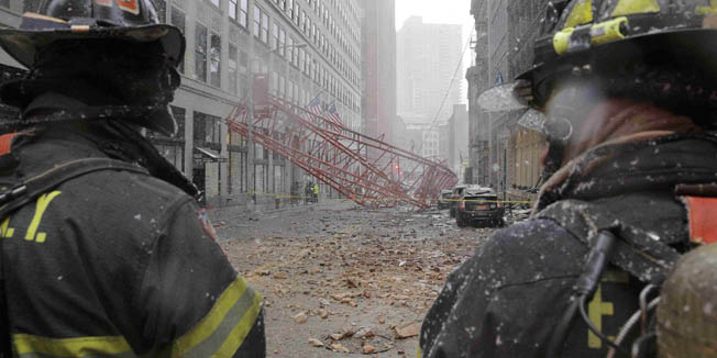 New York City firemen survey a massive construction crane collapse on a street in downtown Manhattan in New York February 5, 2016. The accident killed at least one person and seriously injured two others, a spokesman for the New York City Fire Department said.   REUTERS/Brendan McDermid    