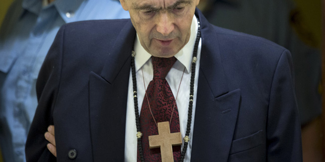 Zdravko Tolimir, a Bosnian Serb general convicted of genocide in the 1995 Srebrenica massacre, is escorted by U.N. security guards as he arrives in the courtroom of the the Yugoslav war crimes tribunal who delivered its judgment in his appeal case in The Hague, Netherlands, Wednesday, April 8, 2015. REUTERS/Peter Dejong/Pool - RTR4WII9
