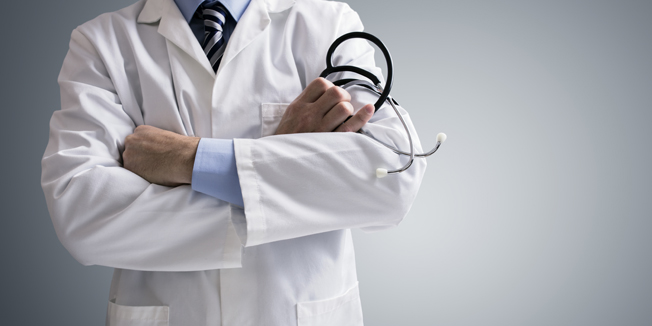 Doctor holding a stethoscope with arms crossed and copy space