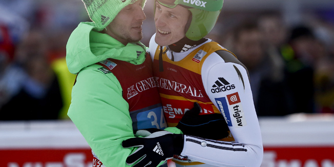 Peter Prevc of Slovenia reacts with teammate Robert Kranjec after winning the second jumping of the 64th four-hills ski jumping tournament in Garmisch-Partenkirchen, southern Germany, January 1, 2016.   REUTERS/Michael Dalder  - RTX20PYP