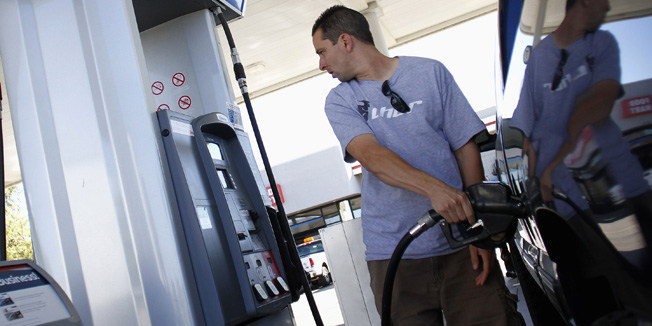 Kenny Sharrar pumps fuel into his truck at a Chevron gas station in Buckeye, Arizona October 27, 2011. Chevron, the second largest U.S.-based oil and gas producer, will report third quarter earnings on Friday.  REUTERS/Joshua Lott (UNITED STATES - Tags: BUSINESS ENERGY) - RTR2TADP