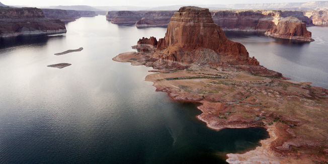 Dry land (R) that would be under water when the lake is full is seen next to Gregory Butte in Lake Powell near Page, Arizona, May 26, 2015. Lake Powell on the Colorado River provides water for Nevada, Arizona and California. A severe drought in recent years, combined with withdrawals that many believe are not sustainable, has reduced its levels to only about 42 percent of its capacity. REUTERS/Rick Wilking  PICTURE 8 OF 26 FOR WIDER IMAGE STORY 