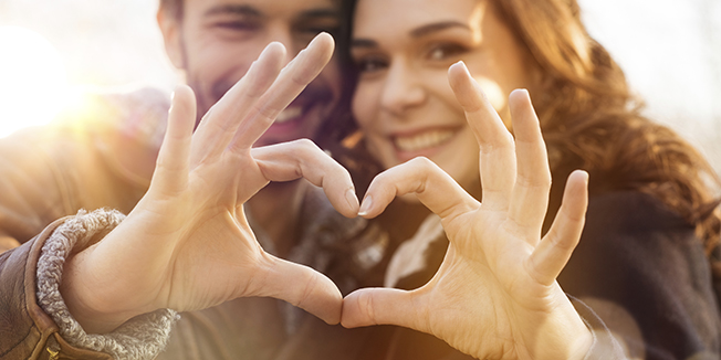 Closeup of couple making heart shape with hands
