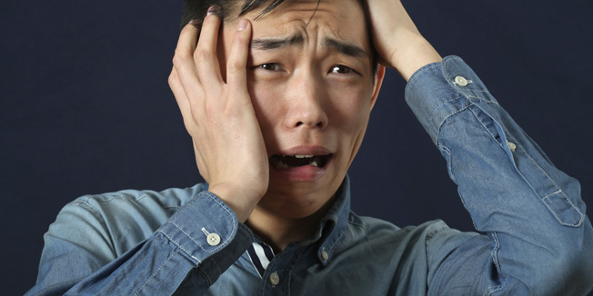 Disappointed young Asian man crying and looking sideways