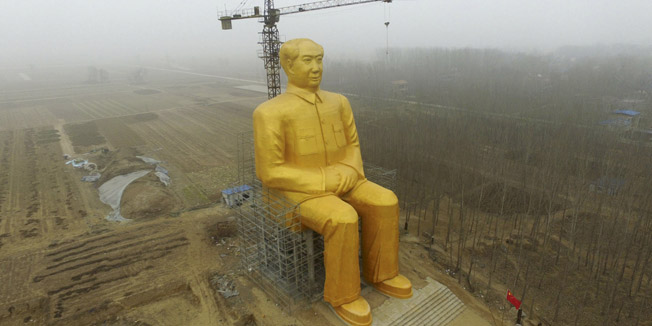 A crane is seen next to a giant statue of Chinese late chairman Mao Zedong under construction near crop fields in a village of Tongxu county, Henan province, China, January 4, 2016. According to local villagers, several entrepreneurs spent nearly 3 million yuan (460,000 USD) to build the 36.6-metre-high statue covered in golden paint, local media reported. REUTERS/Stringer ATTENTION EDITORS - THIS PICTURE WAS PROVIDED BY A THIRD PARTY. THIS PICTURE IS DISTRIBUTED EXACTLY AS RECEIVED BY REUTERS, AS A SERVICE TO CLIENTS. CHINA OUT. NO COMMERCIAL OR EDITORIAL SALES IN CHINA. TPX IMAGES OF THE DAY
