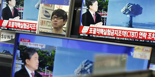 A sales assistant watches TV sets broadcasting a news report on North Korea's nuclear test, in Seoul, January 6, 2016. REUTERS/Kim Hong-Ji
