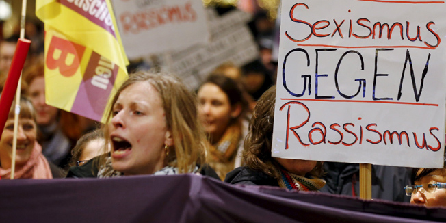 Women shout slogans and hold up a placard that reads 