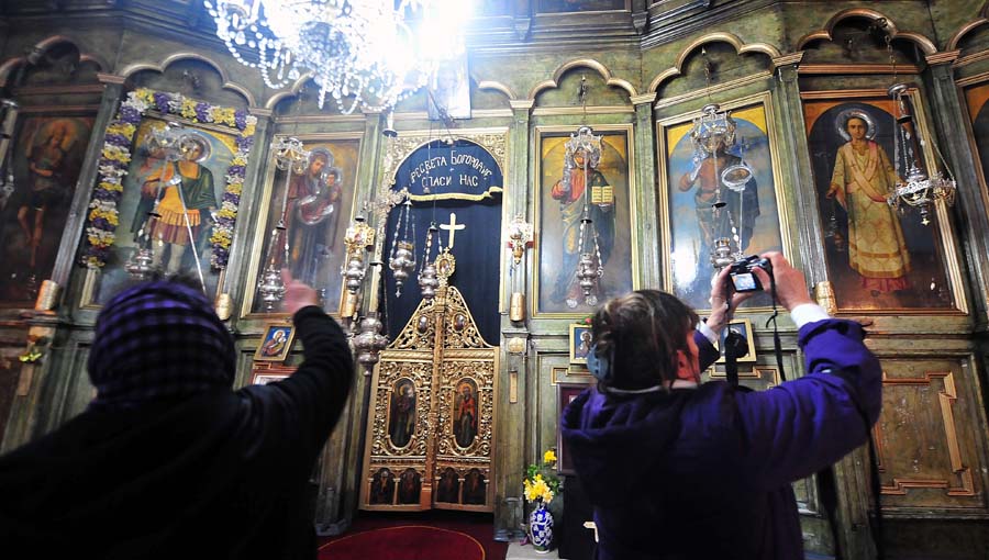 Skopje, 080412.Nesvakidasnji fenomen prociscavanja fresaka poceo se dogadjati u unutrasnjosti poznate skopske crkve Sveti Velikomucenik Dimitrija. Freske u unutrasnjosti crkve, na kojima se godinama talozio dim od izgorjelih svijeca koje su palili vjernici postupno su poceli dobivati svoju prirodnu boju. Naslage dima pocele su blijediti, a na povrsinu je izasla prirodna boja freski. Crkvu su danas posjetili poglavar Makedonske pravoslavne crkve, Arhiepiskop Ohridski i Makedonski, gospodin gospodin Stefan, kao I brojni vjernici koji pale svijece i dodiruju freske da bi osijetili cudo. Prirodne boje najvise se vracaju na oreolima iznad glava naslikanih svetaca, isto kao i na dio njihove nosnje naslikane sa zlatnom bojom. Foto: Maja Zlatevska / Cropix