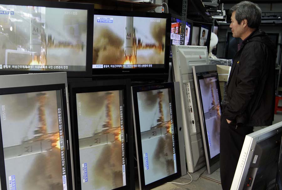 A man watches a TV news showing a file video of North Korea's missile launch at a home appliance retailer in Seoul, South Korea, Friday, April 13, 2012.  North Korea's much-anticipated rocket launch ended quickly in failure early Friday, splintering into pieces over the Yellow Sea soon after takeoff.  (AP Photo/Lee Jin-man)