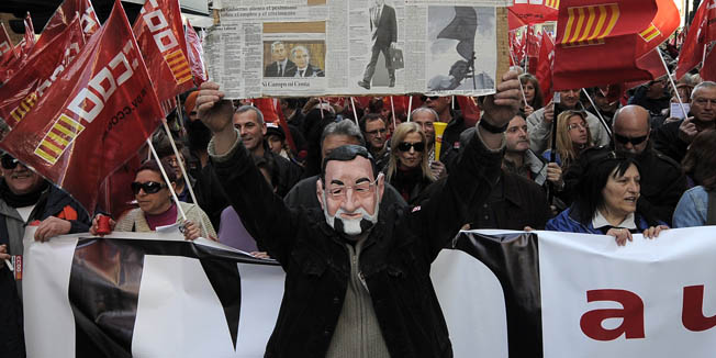 A man wears a mask of the president of the Spanish govermment Mariano Rajoy  during a protest march against the government new labour reform in on February 19, 2012 in Valencia. Hundreds of thousands of people, many waving red and white union flags, protested across Spain today against sweeping labour market reforms that make it easier to slash pay and lay off workers. Spain's two biggest unions, the CCOO and UGT, organised protests in 57 cities against the reforms which Spain's new conservative government argues are needed to revive the economy and slash a jobless rate of 22.85 percent, the highest in the developed world. AFP PHOTO / JOSEP LAGO