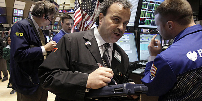Trader Gerard Farco, center, works on the floor of the New York Stock Exchange Monday, April 23, 2012. Stocks are opening sharply lower with new worries about Europe's health. (AP Photo/Richard Drew)