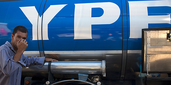 A worker gestures beside an YPF oil company truck near a plant in La Plata, Argentina, Thursday April 19, 2012. Argentine President Cristina Fernandez has defended the move to re-nationalization of YPF as part of a drive to restore her country's sovereignty, increase oil production and rely less on hydrocarbon imports.(AP Photo/Natacha Pisarenko)