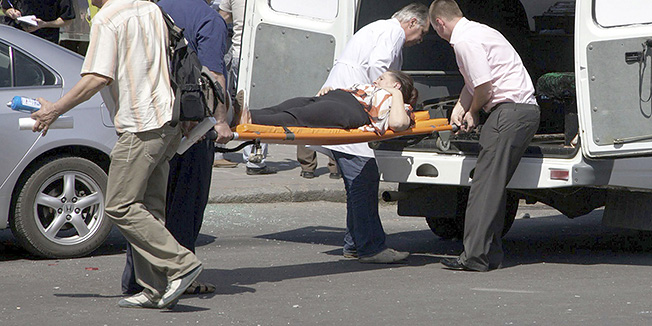 People assist injured after an explosion in Dnipropetrovsk, Ukraine, Friday, April 27, 2012.  Ukraine officials say dozens of people including schoolchildren, were injured in four blasts in the eastern Ukrainian city. (AP Photo/Dmitriy Dvorsky)