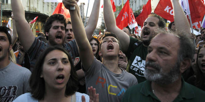 Members of Coalition of the Radical Left party (SYRIZA) shout slogans during Alexis Tsipras' speech in Athens, Thursday, May 3, 2012. The country will hold national elections this Sunday, with opinion polls indicating no party will win enough of a majority to form a government without seeking the backing of another party to form a coalition. (AP Photo/Petros Giannakouris)