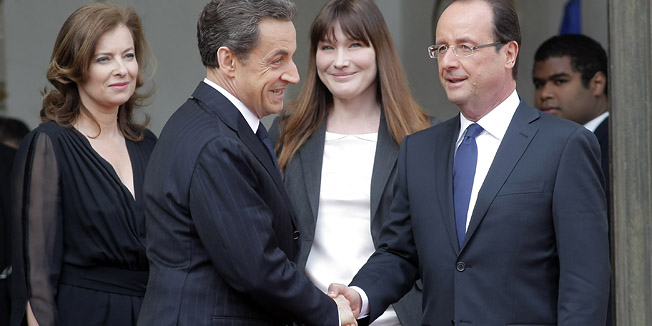 New French President Francois Hollande, right, shakes hands with outgoing President Nicolas Sarkozy while Hollande's companion Valerie Trerweiler, behind right, and Carla Bruni-Sarkozy, behind center, look on, Tuesday, May 15, 2012 after the handover ceremony at the Elysee Palace in Paris.  (AP Photo/Thibault Camus)