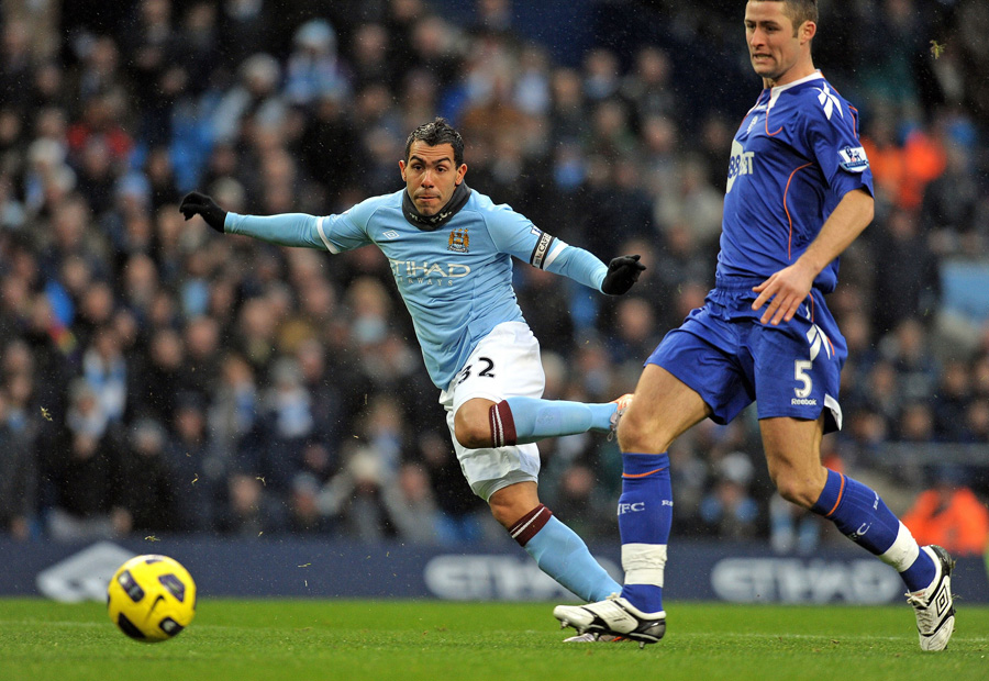 Manchester City's Argentinian striker Carlos Tevez (L) scores the opening goal, as Bolton's English defender Gary Cahill (R) looks on during the English Premier League football match between Manchester City and Bolton Wanderers at the City Of Manchester Stadium in Manchester, north-west England on December 4, 2010. AFP PHOTO/ANDREW YATESFOR EDITORIAL USE ONLY Additional licence required for any commercial/promotional use or use on TV or internet (except identical online version of newspaper) of Premier League/Football League photos. Tel DataCo +44 207 2981656. Do not alter/modify photo.