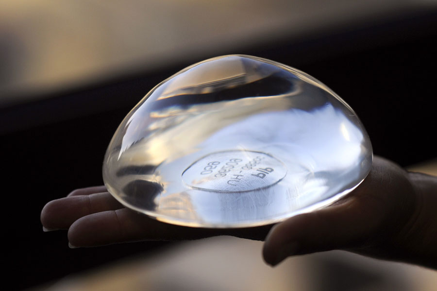 A picture taken on January 3, 2012 in Marseille, southeastern France, shows a breast implant produced by the implant manufacturer Poly Implant Prothese company (PIP) with PIP identity card. The now-bankrupt PIP was shut down and its products banned in 2010 after it was revealed to have been using industrial-grade silicone gel that caused abnormally high rupture rates. Between 300,000 and 400,000 women in 65 countries from Europe to Latin America have received implants made with sub-standard silicone gel by PIP, once the world's third-largest producer of silicone implants. AFP PHOTO / ANNE-CHRISTINE POUJOULAT