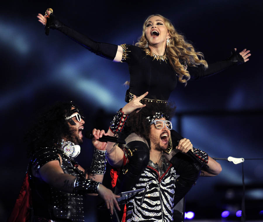Singer Madonna (R) performs with Redfoo and Sky Blu (L) of LMFAO during the NFL Super Bowl XLVI game halftime show on February 5, 2012 at Lucas Oil Stadium in Indianapolis, Indiana. AFP PHOTO / TIMOTHY A. CLARY The Giants defeated the Patriots 21-17. AFP PHOTO / TIMOTHY A. CLARY