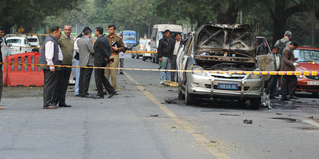 Investigators work the scene of a vehicle that exploded near the Israeli embassy in New Delhi on February 13, 2012.  An Israeli embassy car blew up February 13 in the Indian capital, injuring an Israeli diplomat and one other person, but it was not immediately known whether the explosion was caused by a bomb, officials said.   AFP PHOTO/SAJJAD HUSSAIN