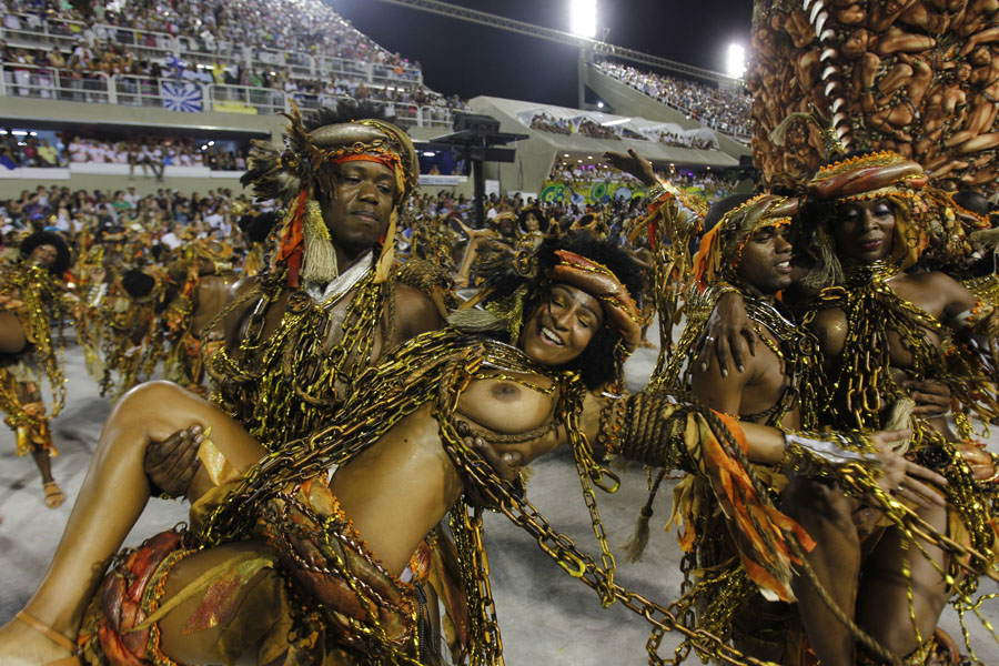 EDS:  NOTE NUDITY -- Performers from the Beija Flor samba school parade during carnival celebrations at the Sambadrome in Rio de Janeiro, Brazil, Monday, Feb. 20, 2012.  Millions watched the sequin-clad samba dancers at Rio de Janeiro's iconic Carnival parade.  (AP Photo/Victor R. Caivano)