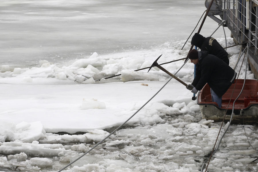 People break the ice on a frozen part of the  Danube River, in Belgrade, Serbia, Monday, Feb. 20, 2012. Big chunks of melting ice moving on the Danube River have damaged hundreds of small boats and several restaurants located on rafts, officials said Monday. The thick ice, which had closed hundreds of miles (kilometers) of Europe's busy waterway during the region's recent cold snap, started moving Sunday afternoon because of rising temperatures.(AP Photo/Darko Vojinovic)