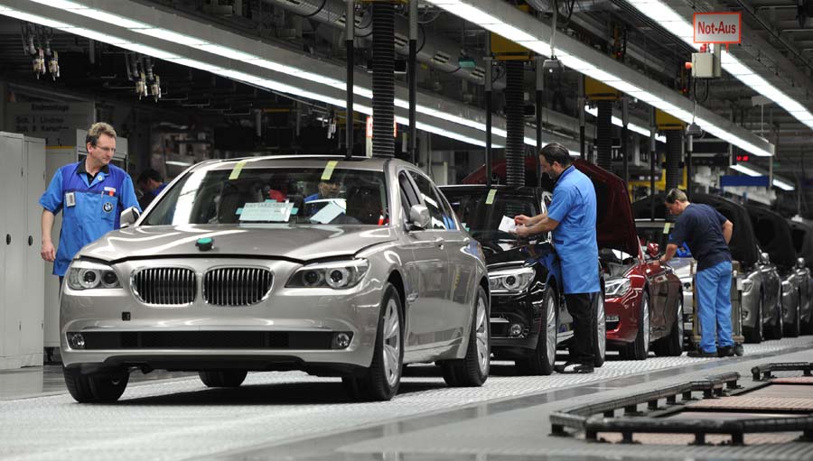 Employees work at the assembly line of the German carmaker BMW plant in Dingolfing, southern Germany, on March 23, 2012. At this plant BMW oldest employees have special ergonomic workspace as one in five of them was older than 50 in 2010 and the rate could double untill 2020. AFP PHOTO/CHRISTOF STACHE