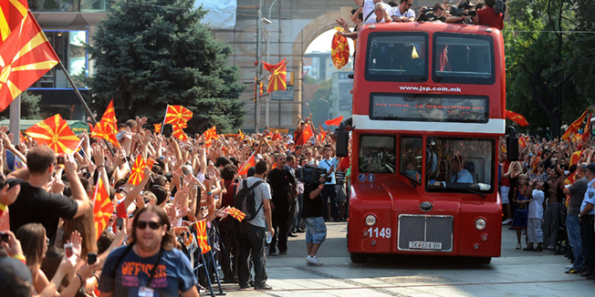 Members of the Macedonian national basketball team are cheered by fans while riding on the slashed roof double-decker bus on their triumphant return to Skopje, on September 19, 2011.The Macedonian basketball team won the high fourth place in the European Basketball Championship in Lithuania, causing sensation across the continent. Tens of thousands of Macedonians today celebrated the European success on the Skopje central square with the members of the national basketball team. AFP PHOTO/ROBERT ATANASOVSKI