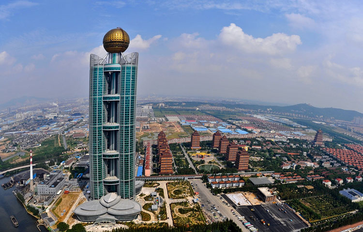 This aerial photo taken on September 25 shows the Longxi International Hotel, standing at 328 metres (1,082-feet) high and costing 470 million USD to build, in Huaxi, which is still classed as a village in east China's Jiangsu province.  One of China's tallest buildings has opened for business in the nation's 'wealthiest village' of Huaxi, a symbol of the country's breakneck economic growth, officials and state press said on October 10, 2011.        CHINA OUT      AFP PHOTO