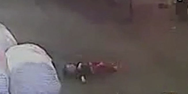 In this image taken from an Oct. 13, 2011 security video camera footage run by China's TVS via APTN, a person cycles by 2-year-old girl, identified as Wang Yue, after she was run over by a van in Foshan in southern China's Guangdong province. The video showing a toddler being struck twice by vans and then ignored by passers-by is sparking outrage in China and prompting soul-searching over why people didn't help the child. (AP Photo/TVS via APTN)  CHINA OUT, NO SALES, NO ARCHIVES, EDITORIAL USE ONLY 