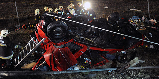 Hungarian firefighters work near the wreckage of Romanian minibus after a Romanian truck ran over to the opposite lane and collided head-on with the minibus on a street in Maroslele, Hungary, early Monday, Oct. 31, 2011. Fourteen people travelling in the minibus, three children and four women among them, were killed, one passenger is in critical condition and the driver of the truck was seriously injured in the accident. (AP Photo/MTI, Zoltan Gergely Kelemen)