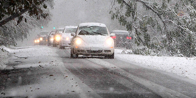 Cars drive under and around a fallen tree on Route 303 in Valley Cottage, N.Y., on Saturday, Oct. 29, 2011. Heavy snow took down many trees throughout Rockland County as a classic nor'easter chugged along up the East Coast dumpinging anywhere from a dusting of snow to about 10 inches throughout the region. ( AP Photo /The Journal News , Peter Carr) NYC METRO OUT; TV OUT; MAGS OUT, NO SALES