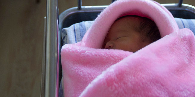 In this Tuesday Oct. 11, 2011 photo, a newborn North Korean baby girl lies in crib in her mother's hospital room inside Pyongyang Maternity Hospital in Pyongyang, North Korea. (AP Photo/David Guttenfelder)