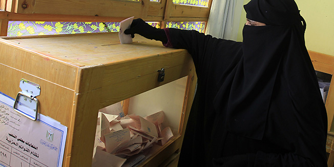 TOPSHOTSAn Egyptian woman casts her ballot at a polling station in the Manial neighbourhood of Cairo on November 28, 2011. Post-revolution Egypt headed to the polls for a chaotic election clouded by violence and a political crisis, the start of a long process to bring democracy to the Arab world's most populous nation.    AFP PHOTO/ MAHMUD HAMS