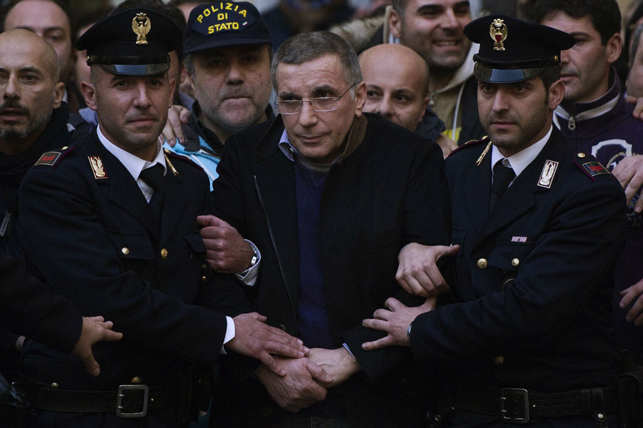 Italian policemen escort Michele Zagaria (C), the boss of the Casalesi clan outside the Police's headquarters in Caserta following his arrest on December 7, 2011. Italian police on Wednesday arrested Michele Zagaria, 53, the most senior boss of the Camorra mafia still at large, digging through a secret bunker near Naples to end his 16 years on the run.  AFP PHOTO / ROBERTO SALOMONE