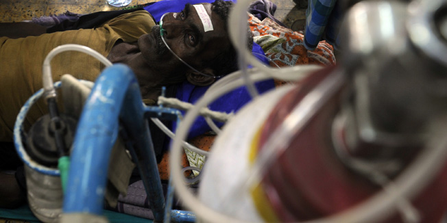 A victim receives medical treatment at the Diamond Harbour hospital in Diamond Harbour, after dozens died and many injured drinking boot-leg liquor in several villages south of Kolkata, on December 15, 2011. A batch of home-brewed liquor possibly laced with a lethal dose of the highly toxic chemical methanol has killed more than 100 people in eastern India, an official told AFP. AFP PHOTO/Dibyangshu SARKAR