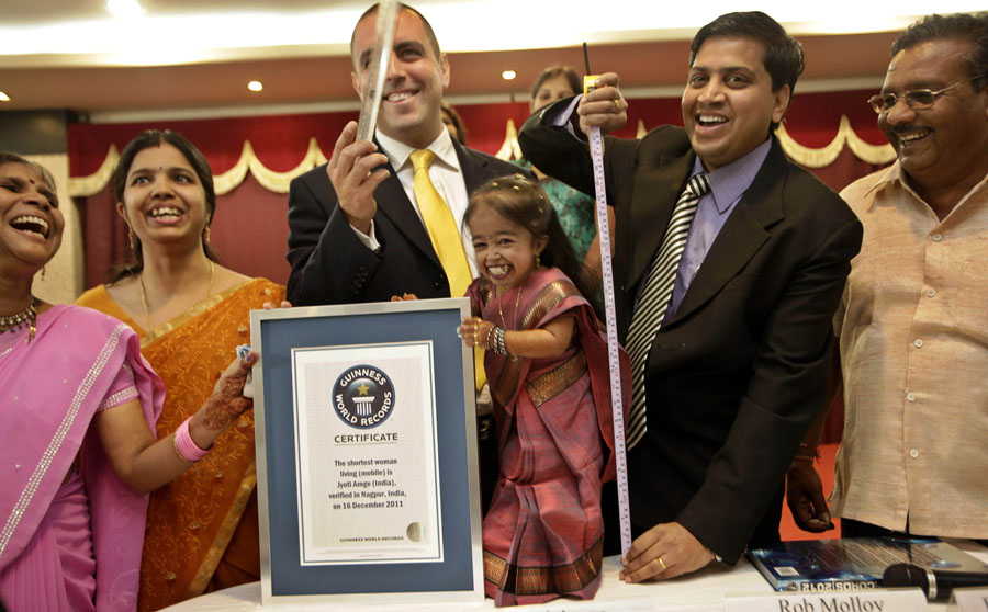 Guinness World Records adjudicator Rob Molloy, center, and Dr. Manoj Pahukar of Wockhardt hospital, second right, measures Jyoti Amge, 18 years, as her mother Ranjana Amge, left, and father Kishanji Amge, right, look on in Nagpur, India, Friday, Dec. 16, 2011. Amge, a high school student in central India, was recognized as the world's shortest woman by Guinness World Records on Friday as she turned 18 and said she hopes to earn a degree and make it in Bollywood. (AP Photo/ Manish Swarup)