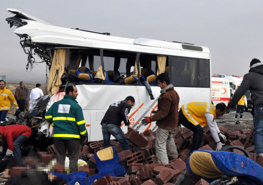 Rescue workers work near the site of a traffic accident on December 21, 2011 in Diyarbakir. Twenty-four people were killed on Wednesday when a brick-loaded truck collided with a bus in southeastern Turkey, the local governor said. The crash took place near Salat, in Diyarbakir province, Diyarbakir governor Mustafa Toprak was quoted as saying by the Anatolia news agency. Television broadcasts said eight other people were injured. Deadly road accidents are a daily occurrence in Turkey, where respect for traffic rules is minimal. According to police figures, some 4,000 people were killed and more than 211,000 injured in about 1.1 million traffic accidents across the country in 2010. (Picture was blurred at source to hide graphic content).  AFP PHOTO / ANATOLIA NEWS AGENCY - ERCAN ATAY = TURKEY OUT