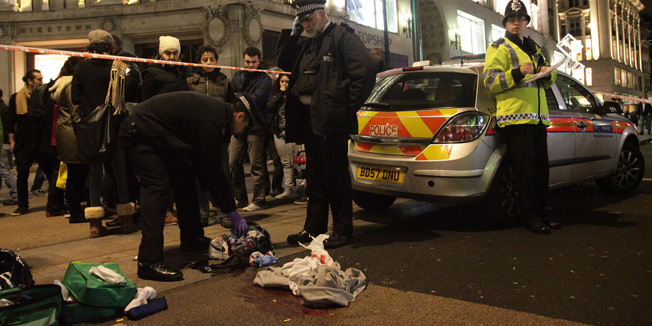 Police examine blood stained clothes at the scene of a second stabbing close to the junction of Oxford Street and Regent Street in central London, Monday Dec. 26, 2011. The victim of the second attack was a male who had been stabbed in the legs. His injuries were not life threatening, police confirmed.  The male is receiving treatment in hospital and it is 
