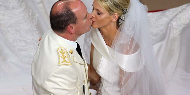 Prince Albert II of Monaco kisses Princess Charlene of Monaco during their religious wedding at the Main Courtyard of the Prince's Palace on July 2, 2011 in Monaco.  AFP PHOTO / VALERY HACHE